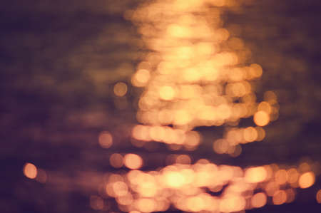 Bokeh of bright golden solar flare reflections for backgroundの写真素材