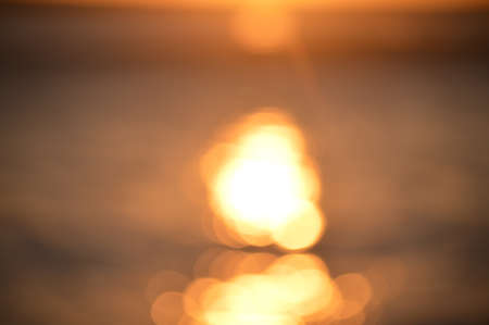 Bokeh of bright golden solar flare reflections for backgroundの写真素材