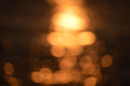 Bokeh of bright golden solar flare reflections for backgroundの写真素材