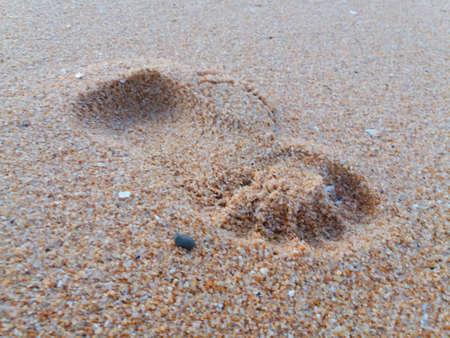 Natural background of human footprint in the wet sandy seaside. Close-up photography on relaxation...