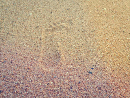 Natural background of human footprint in the wet sandy seaside. Close-up photography on relaxation sign idea designの写真素材