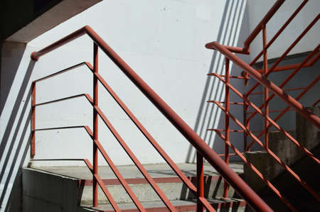 Light staircase with red handrails and concrete walls abstract backgroundの写真素材