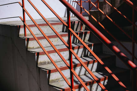 Light staircase with red handrails and concrete walls abstract backgroundの写真素材