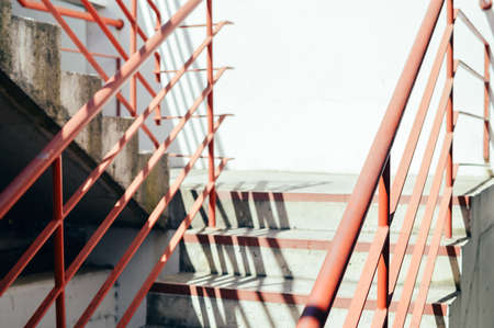 Light staircase with red handrails and concrete walls abstract backgroundの写真素材