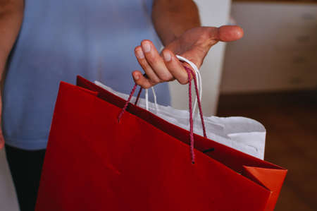 Shopping experience. Close up photography on caucasian male hand holding purchases, light copy space...
