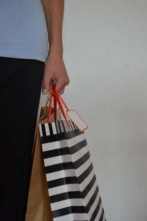 Shopping experience. Close up photography on caucasian male hand holding purchases, light copy space...