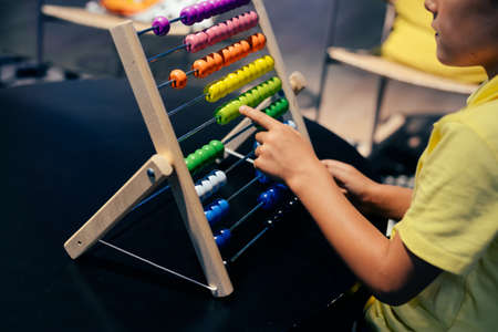 Educational colorful wooden abacus beads on table background. School arithmetic symbol, calculating thinking concept, closeup photographyの写真素材