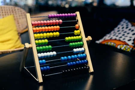 Educational colorful wooden abacus beads on table background. School arithmetic symbol, calculating thinking concept, closeup photographyの写真素材