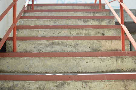 Abstract emergency stairs access for people, gray textured color empty stairway indoors grungy structure backgroundの写真素材