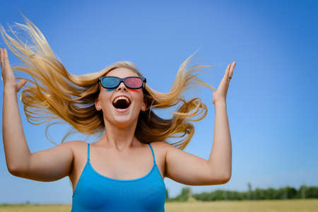 Fun and entertainment. Portrait of attractive surprised girl with 3d glasses watching movie on light blue background. She is emotional, amazing, experience joyful leisure lifestyleの写真素材