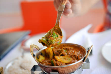 Lamb with spinach, close up of tasty indian food on light table backgroundの写真素材