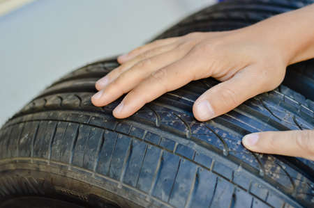 Close up of person checking examining car tyre on the shelf abstract transportation background....
