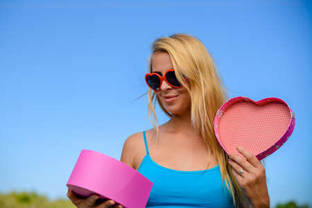 Joyful young woman happy smile hold gift box in hands, bright close up portrait. Emotional delight lovely happiness lifestyle. Amazing excitememntの写真素材