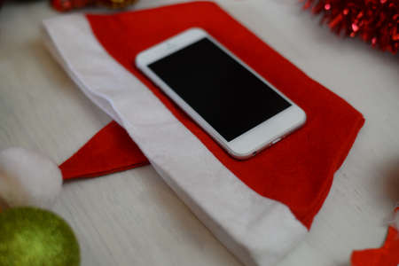 Top view of mobile phone and Christmas decor on wooden background. Mock up closeup photography. Modern technology connection, shopping delivery service, social network, festive happy busy timeの写真素材