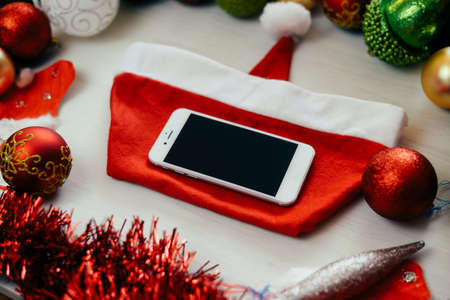 Close up on using mobile phone for Christmas happy New Year season abstract copy space background. Modern use of mobility communication media networking technology and festive decoration abstractionの写真素材