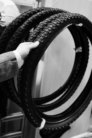 Black and white photography of hand choosing or presenting cycle spare tire. Close upの写真素材
