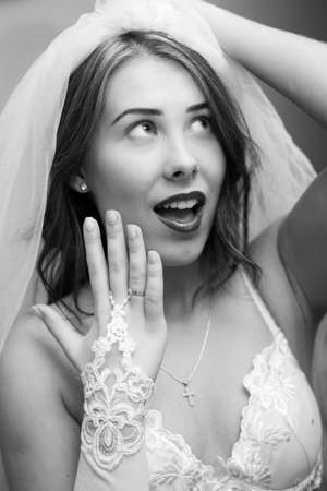 Black and white closeup of beautiful sensual young lady showing engagement ring and happy smiling looking upの写真素材