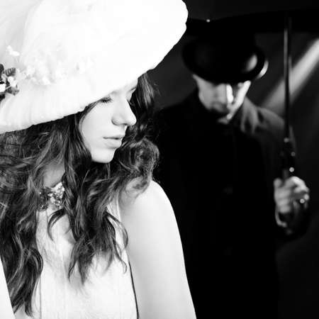 Black white portrait of beautiful young lady over male silhouette, dark background