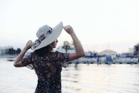 Back side view of attractive woman having fun enjoying summer holiday weekend background. Harbor outdoors, amazing dreamy marine vacation freedom pleasure summertime escape conceptの写真素材