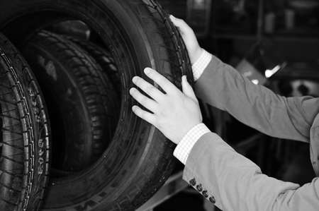 Black and white photography of hands choosing a car tire. closeupの写真素材