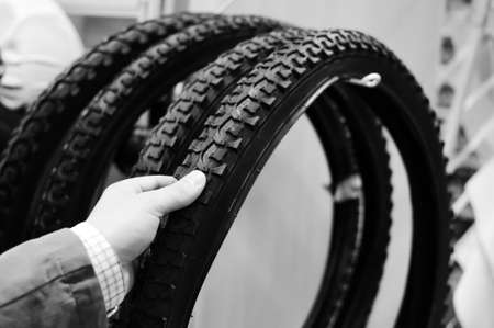 Black and white photography of hand choosing or presenting cycle spare tire. Close upの写真素材