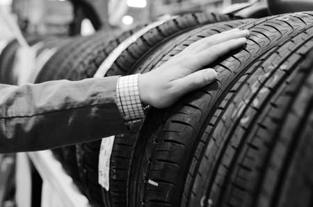 Black and white photography of person hands choosing a car tire. closeupの写真素材