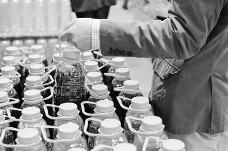 Black and white photography of person choosing buying of liquid bottles の写真素材