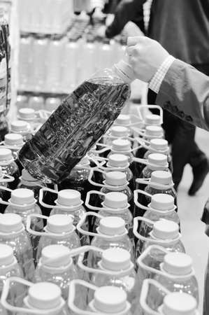 Black and white photography of person choosing buying of liquid bottles の写真素材