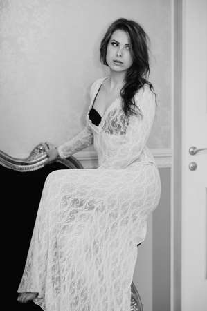 Black and white picture of beautiful gorgeous young lady sitting on luxury sofa relaxingの写真素材