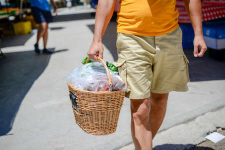 People buying fruits and vegetables. Summer outdoors farm market shopping background. Real purchasing selling natural healthy lifestyle candid closeup image.の写真素材