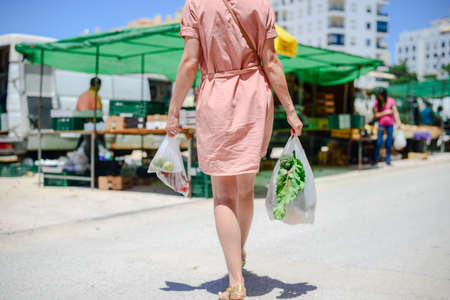 Adult person buying, selecting choosing fresh food abstract background, light day shop market. green commodity groceries consumption life checkoutの写真素材