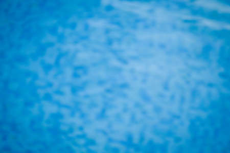 Defocused blurry recreational holiday swimming pool sunny tropical background. Unfocused blurred outdoors for having fun on travel vacation summertime relaxの写真素材