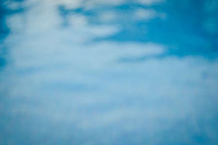 Defocused blurry recreational holiday swimming pool sunny tropical background. Unfocused blurred outdoors for having fun on travel vacation summertime relaxの写真素材