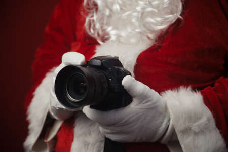 Santa Claus using holding in hands DSLR camera. Christmas and New Year celebration background