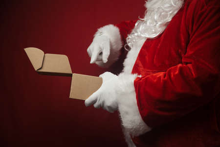 Father Santa Claus holding in hands surprise present gift box seasonal tradition background. Merry Christmas and Happy New Year amazing excitement joyful time!の写真素材