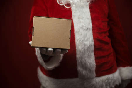 Father Santa Claus holding in hands surprise present gift box seasonal tradition background. Merry Christmas and Happy New Year amazing excitement joyful time!の写真素材