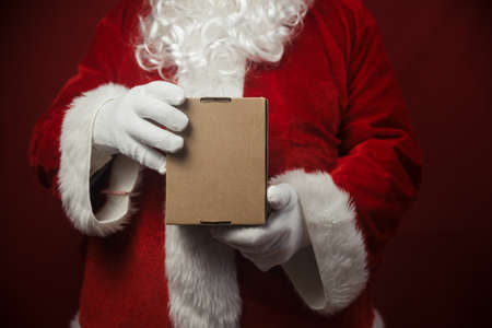 Father Santa Claus holding in hands surprise present gift box seasonal tradition background. Merry Christmas and Happy New Year amazing excitement joyful time!の写真素材