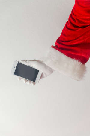 Santa Claus using mobile phone modern smartphone communication technology background. Closeup mock up view. Business service solution and traditional holidaysの写真素材