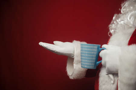 Relaxing Santa Claus drinking holding hot mug, festive leisure lifestyle closeup image. Merry Christmas and Happy New Year amazing excitement joyful seasonal holidays time!の写真素材