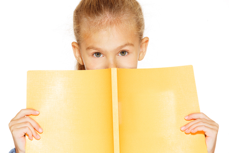Beautiful little girl in blue dress with copybook. Isolated on white.の写真素材