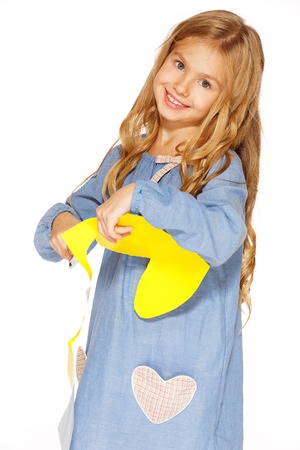 Little cute girl making handmade yellow heartsの写真素材