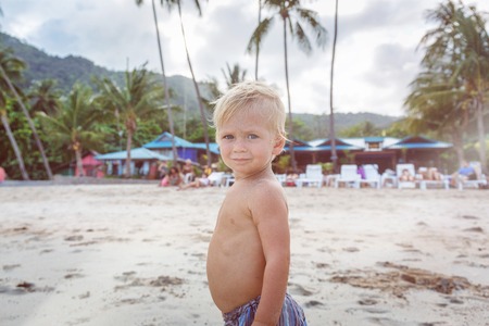 Toddler  walking on a white sand in Thailandの写真素材