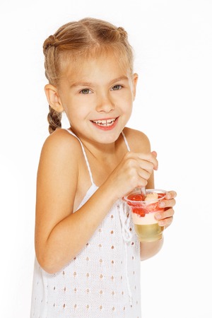 Beautiful little girl with pigtails eating jellyの写真素材