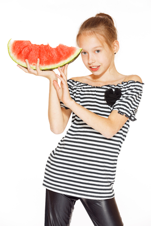 Cute girl eating red juicy watermelon, isolated on whiteの写真素材