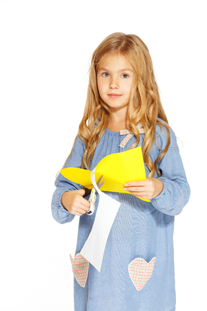 Little cute girl making handmade yellow heartsの写真素材