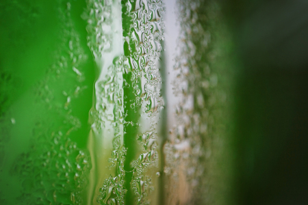 Green glass bottle with condensation on itの写真素材