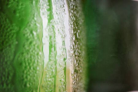 Green glass bottle with condensation on itの写真素材