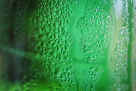 Green glass bottle with condensation on itの写真素材