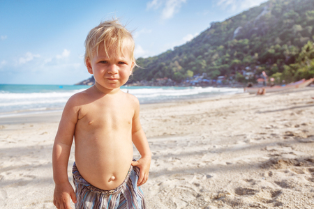 Portrait of a baby with a naked torso on the beachの写真素材