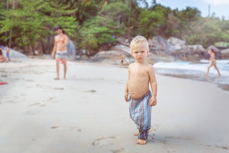 Toddler  walking on a white sand in Thailandの写真素材